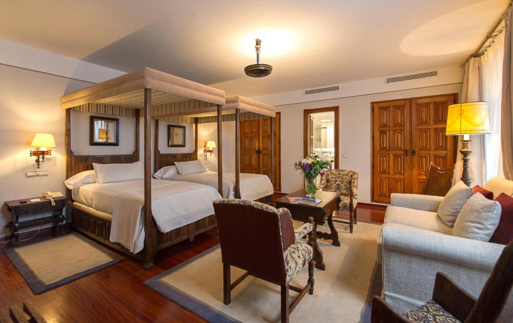 Santiago 的 Parador de Santiago 四柱床套房，扶手椅與木門