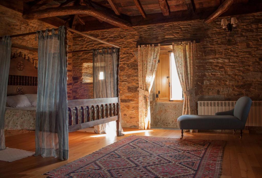 Arzúa 近郊 Pazo Santa María 的四柱床房間，原始石牆與裸露木樑