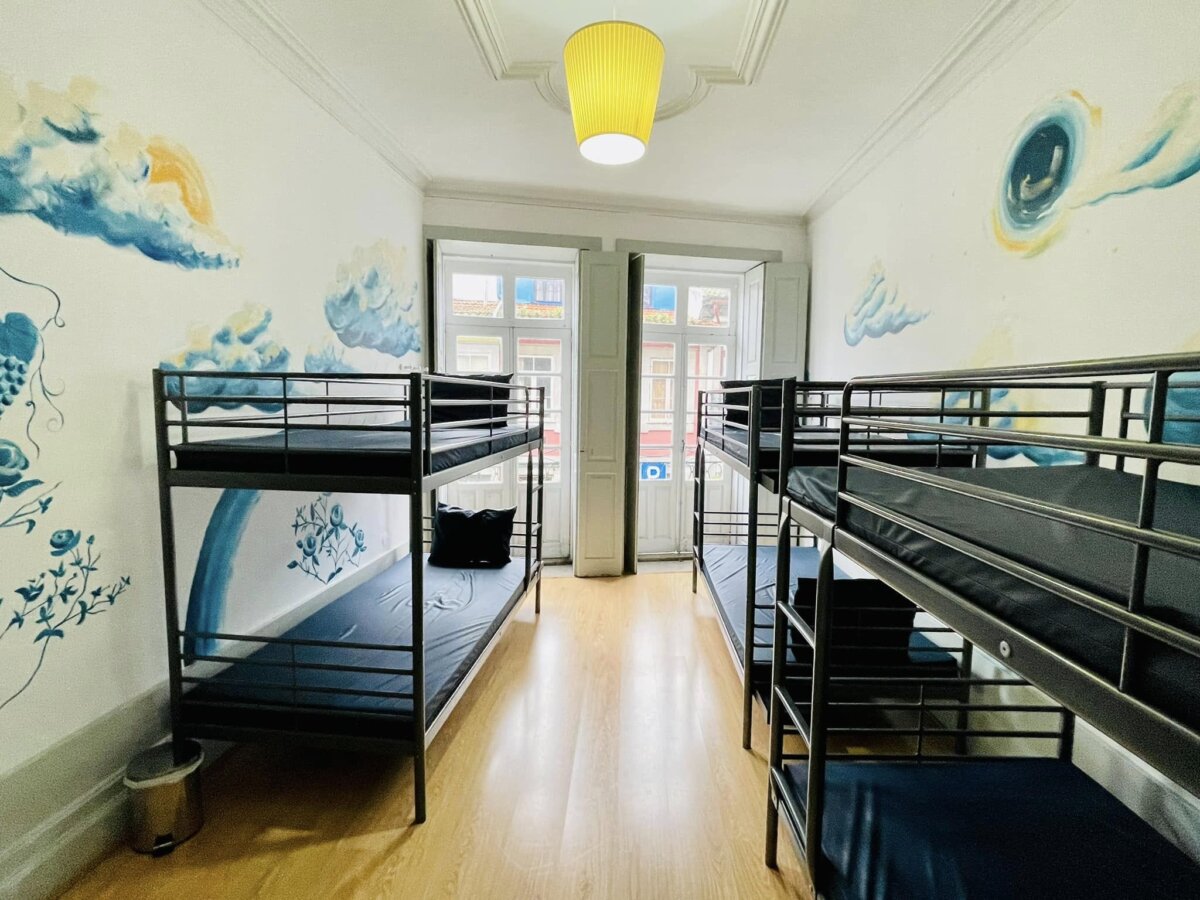Albergue de Peregrinos do Porto 的通舖房,海浪彩繪牆與兩排上下舖