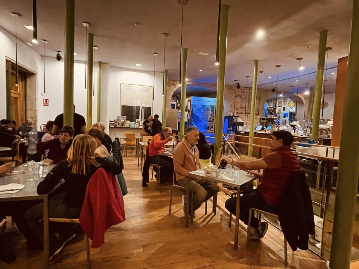 Casa Manolo 店內用餐區坐滿客人，綠色柱子與拱頂石造空間