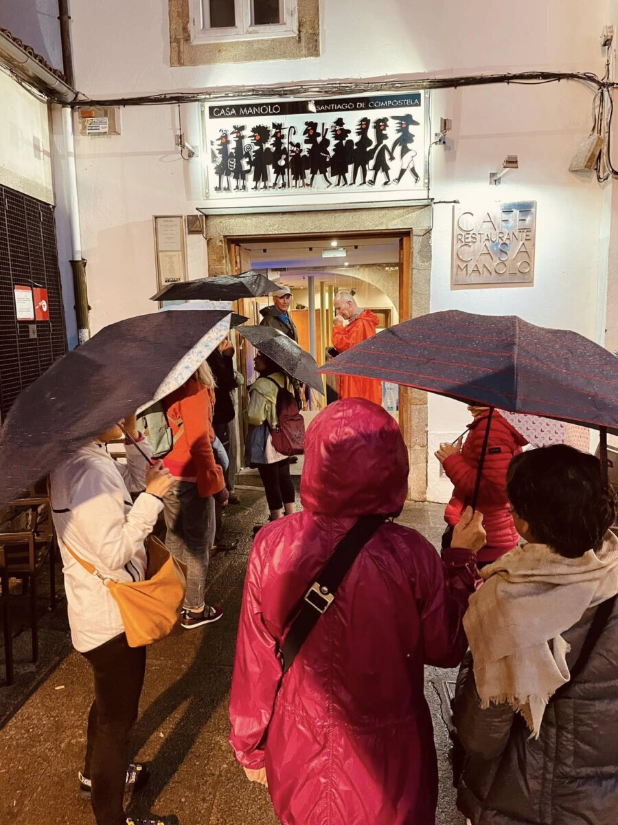 雨天一群朝聖者撐著傘在 Casa Manolo 門口排隊等候入座