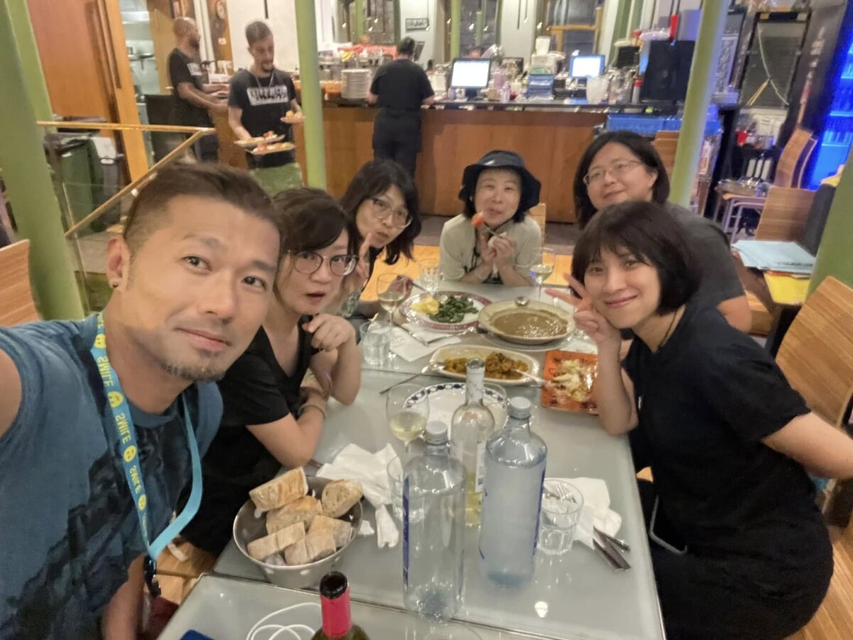 史坦力帶朝聖團在 Casa Manolo 長桌用餐合照，桌上有麵包籃與多道菜