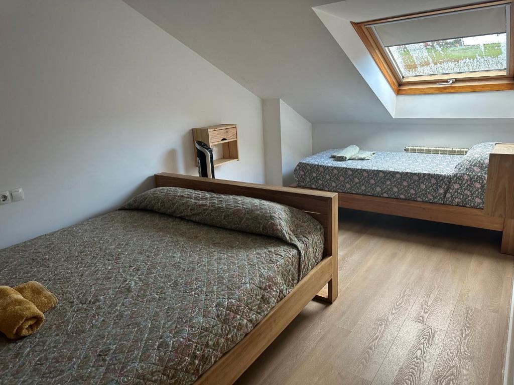 O Pedrouzo 的 Pilgrim's House 閣樓房，斜屋頂天窗與兩張床