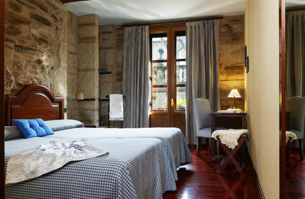 Santiago 的 Hotel Rúa Villar 客房，石牆、木百葉窗與深紅木地板