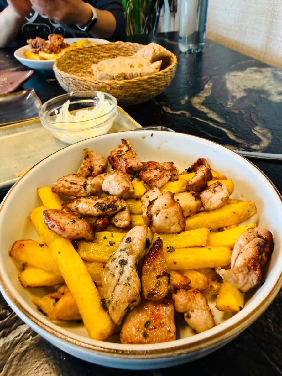 O’San Roquiño 朝聖者套餐的主菜，一大碗煎豬肉塊配薯條，後方有麵包籃和沾醬
